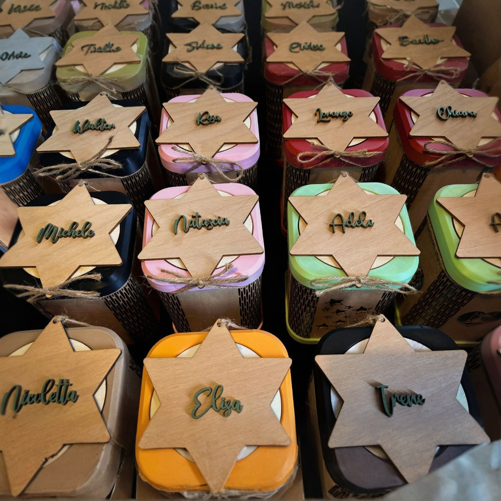 Dettaglio tag in legno con nomi fresati e applicazioni 3D colorate